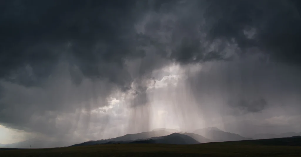 Dark towering cumulonimbus storm cloud weighing millions of tons during rainfall