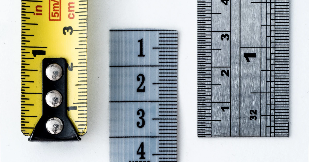 Tape measure and metal rulers showing inch and centimeter markings