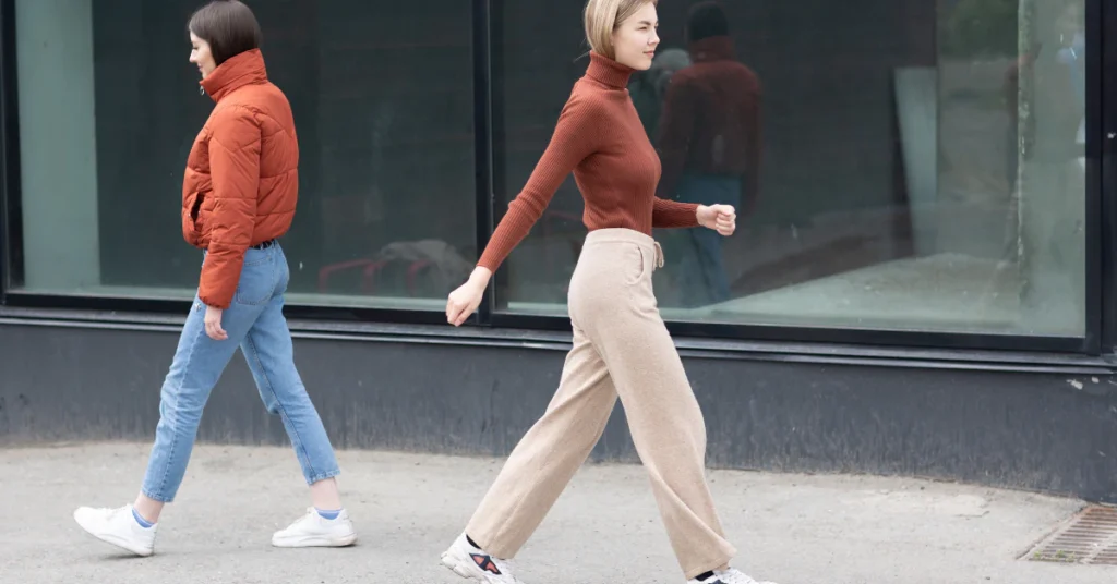 Two people walking side by side on a city sidewalk showing a natural stride
