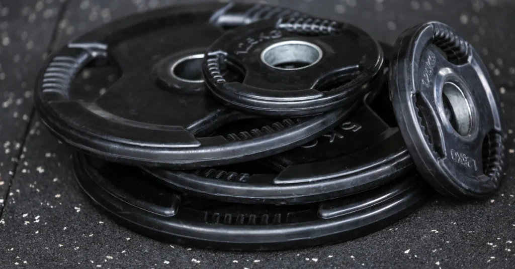 Stack of black weight plates on a gym floor
