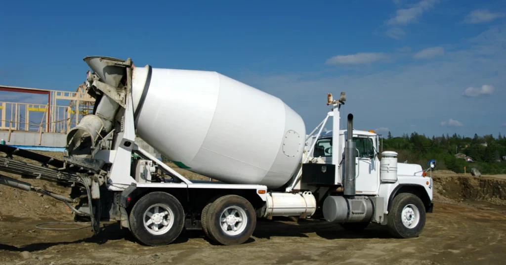 White concrete mixer truck parked on a road